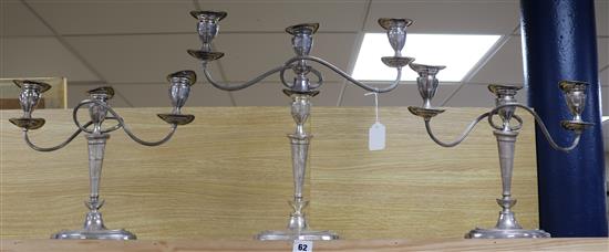 A suite of three silver plated two branch three light oval candelabra, comprising a pair and larger single, tallest 45.5cm.